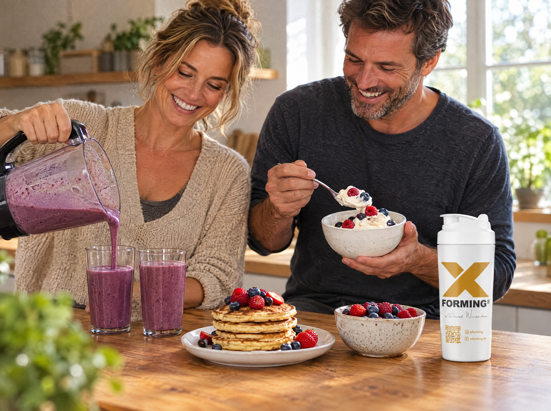 Paar in der Küche mit Beeren-Smoothie, Protein-Creme und Pancakes